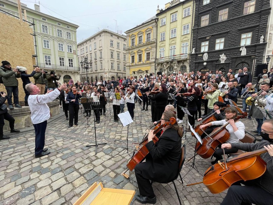 An orchestra gathers in a town square to perform in a protest.