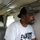 Two men sitting inside an airplane. One is looking out a window.