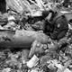 A man crouches next to unexploded ordnance in Ukraine.