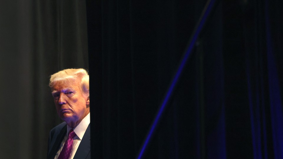 Photograph of Donald Trump peering out from behind a curtain