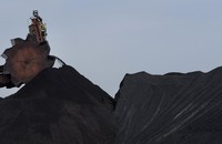 A large machine with a round head loads coal into piles at a coal plant in Letart, West Virginia.