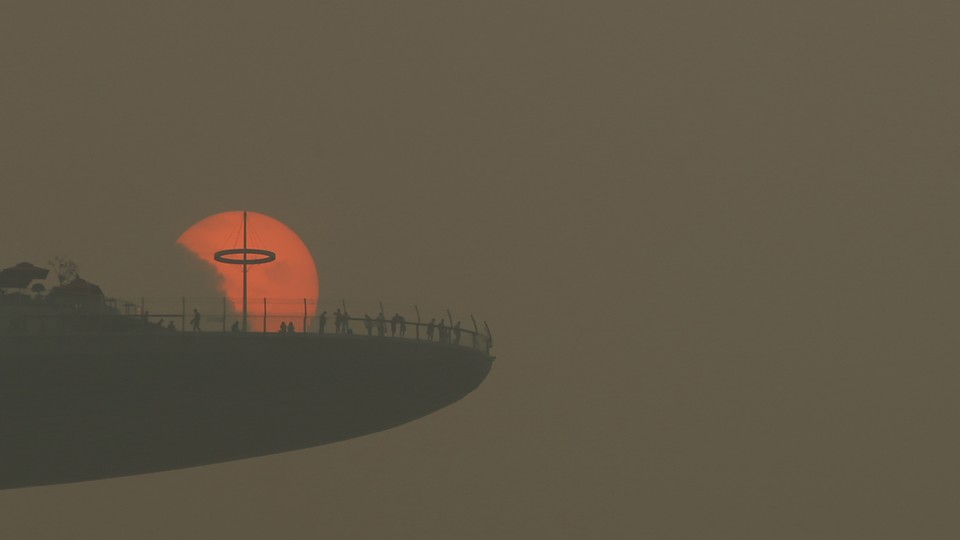 People watch the sunset through hazy air in Singapore.