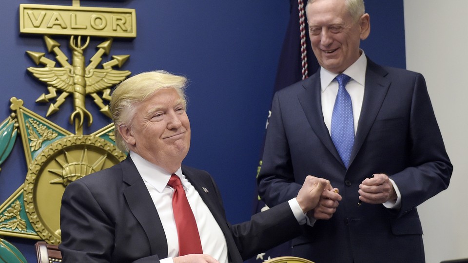 Donald Trump shakes Defense Secretary James Mattis's hand after signing an executive order on immigration.