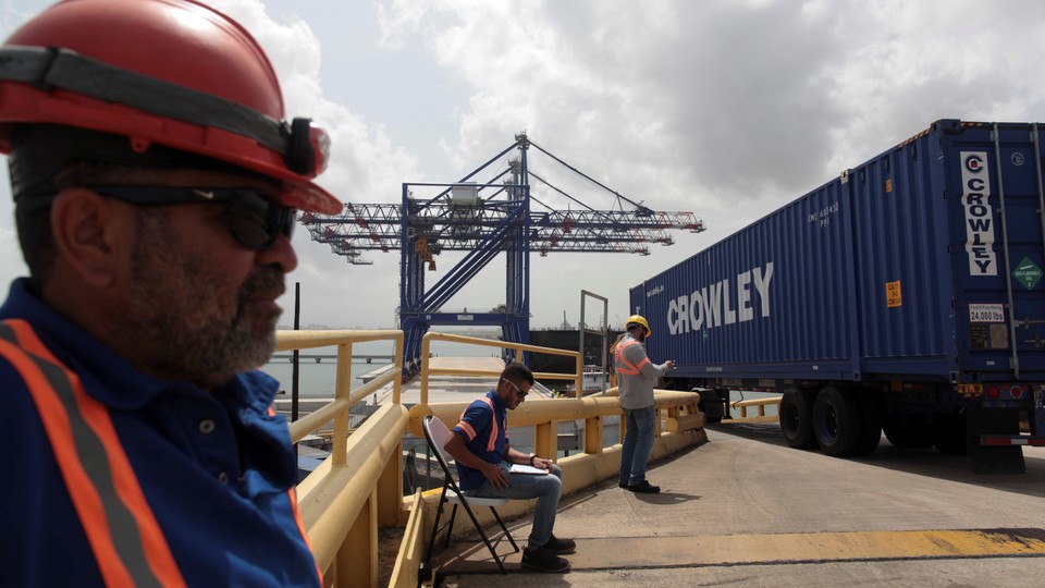 Workers unload a barge at the port of San Juan, Puerto Rico.