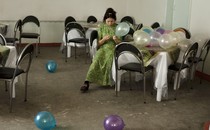 a woman sits at a table with balloons