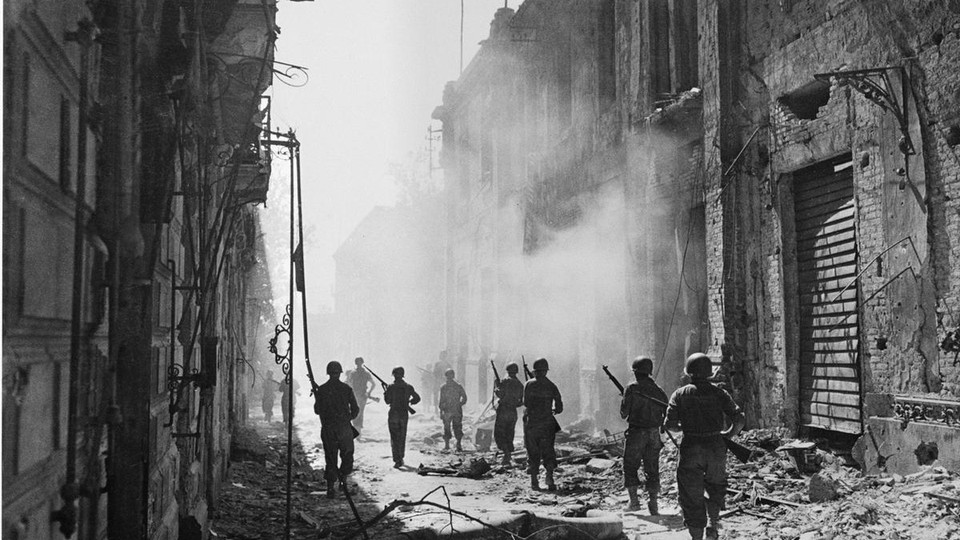 A photograph of soldiers in a street full of rubble