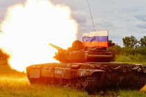 A Russian T-72 tank test-fires with a Russian flag atop it.