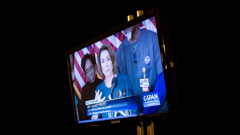 A screen shows Representative Nancy Pelosi, then House minority leader, giving a press conference via C-SPAN.