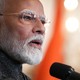 A photo shows Prime Minister Narendra Modi speaking into a microphone.