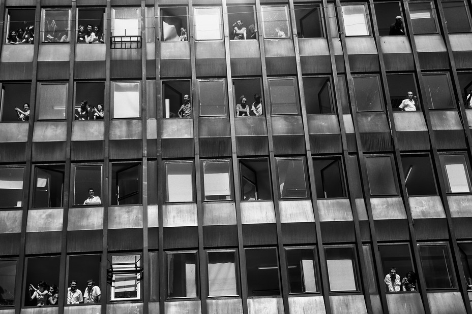 Photo of people watching clashes from a building as protesters clash with Turkish police during Gezi Park protests.