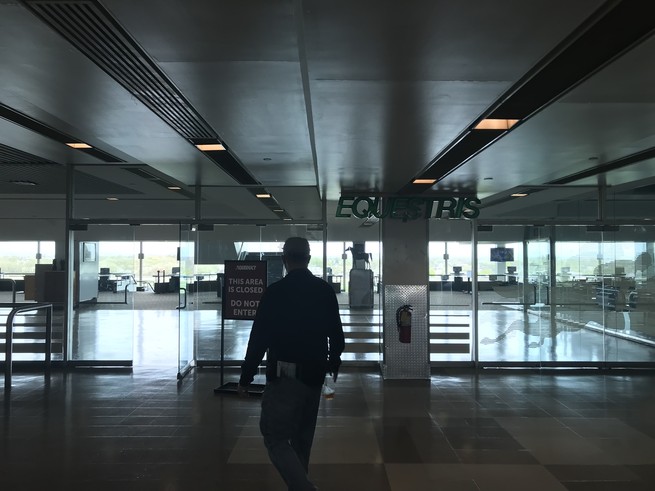 A man walking into an empty room with a sign in front that says THIS AREA IS CLOSED.