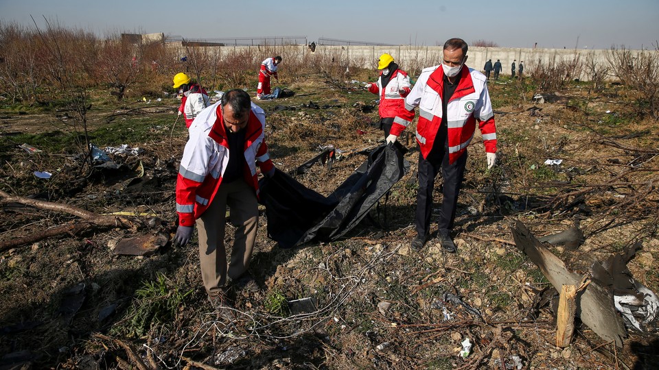 A rescue team carries a body at the site where the Ukraine International Airlines plane crashed after take-off from Iran's Imam Khomeini airport, on the outskirts of Tehran.