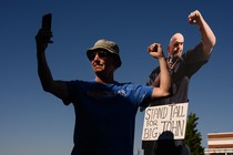 A photograph of a supporter taking a selfie in front of a life-size cutout of John Fetterman