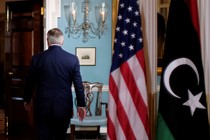 Rex Tillerson walks out of a room.