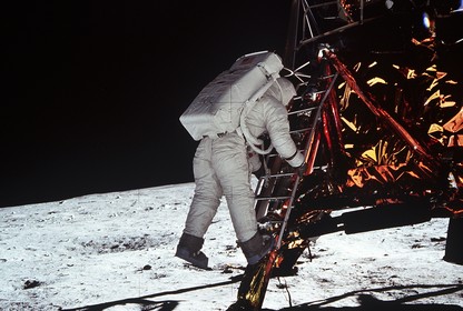 Astronaut Buzz Aldrin steps off the ladder from the lunar module and onto the moon.