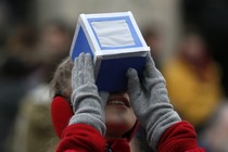 A girl looks through a viewing box. 