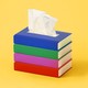 A stack of books with a tissue coming out of the top, like a tissue box.
