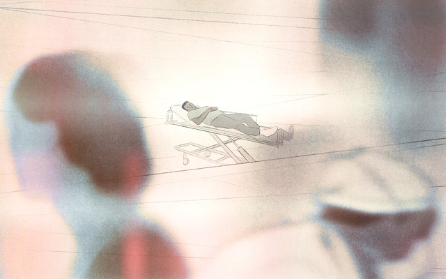 A figure on a stretcher watches as nurses and doctors walk by in the distance