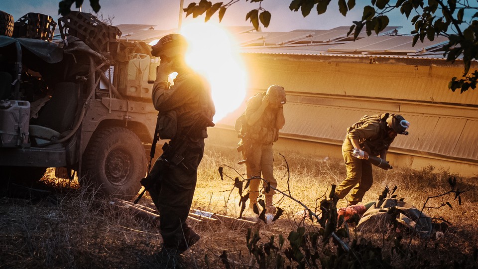 Soldiers take cover as they launch mortar rounds towards Gaza in southern part of Israel, Saturday, Oct. 14, 2023.