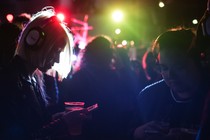 A woman looks at her phone as she takes part in a silent disco.