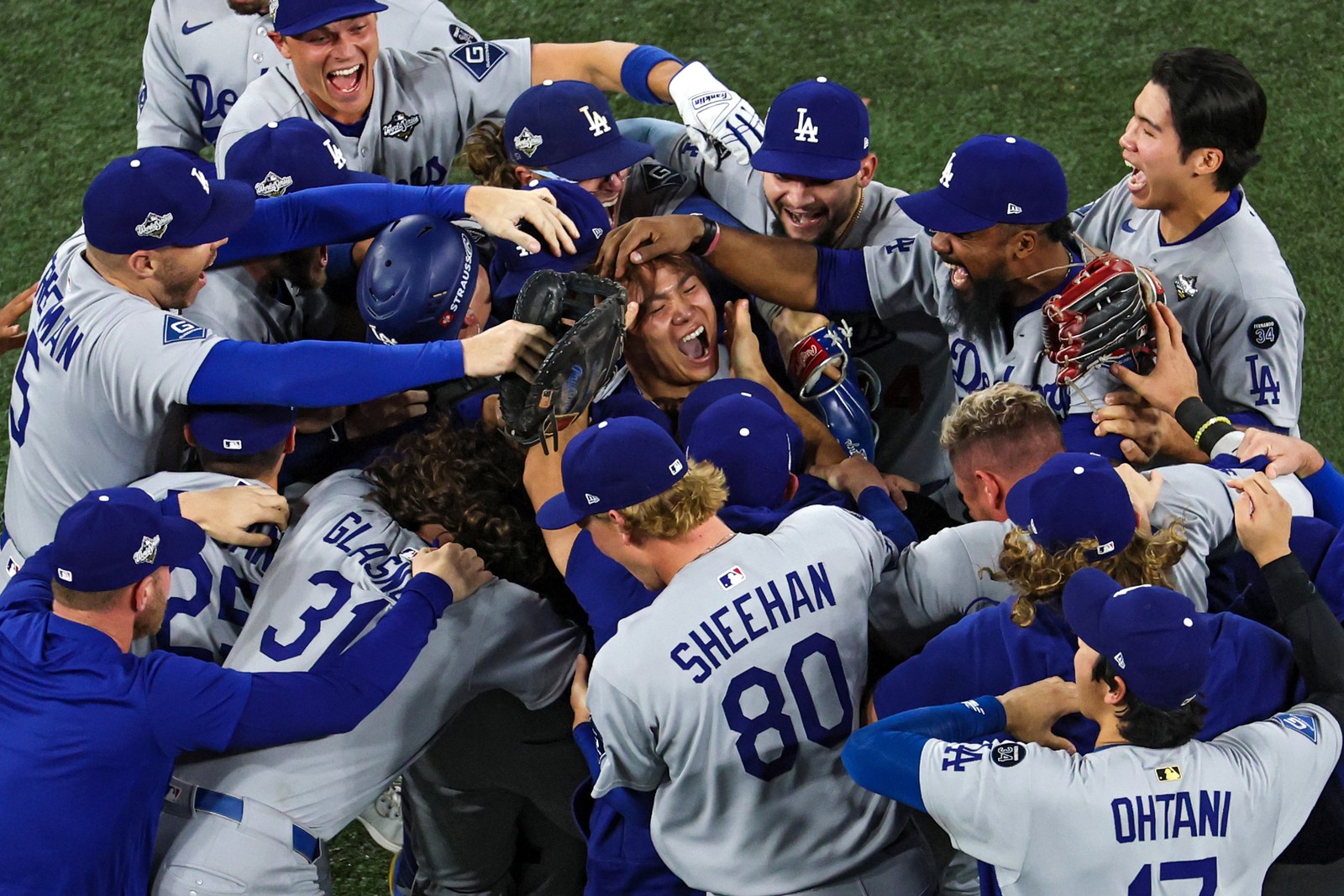 Members of the Los Angeles Dodgers crowd together and celebrate winning the World Series.