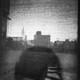 Shadow figure looking over black and white city scene