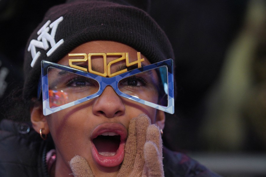 A person shouts while wearing a pair of novelty glasses with the number 2024 on top.