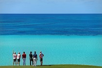 Professional golfers and their caddies study the view at a course in Bermuda.