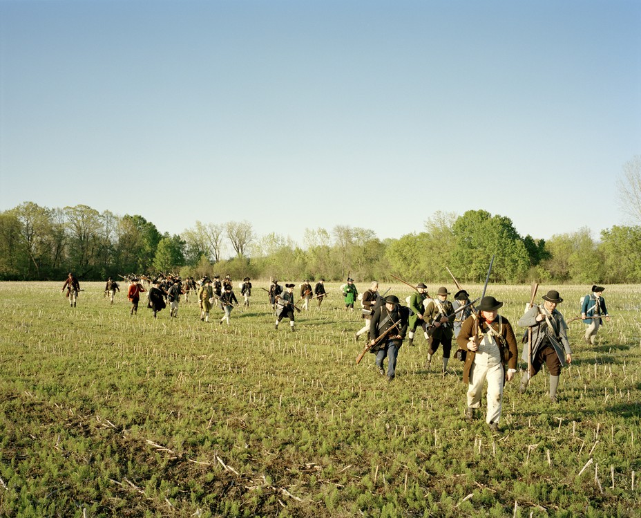 photo of reenactors as American soldiers hiking towards Fort Ticonderoga across an open field