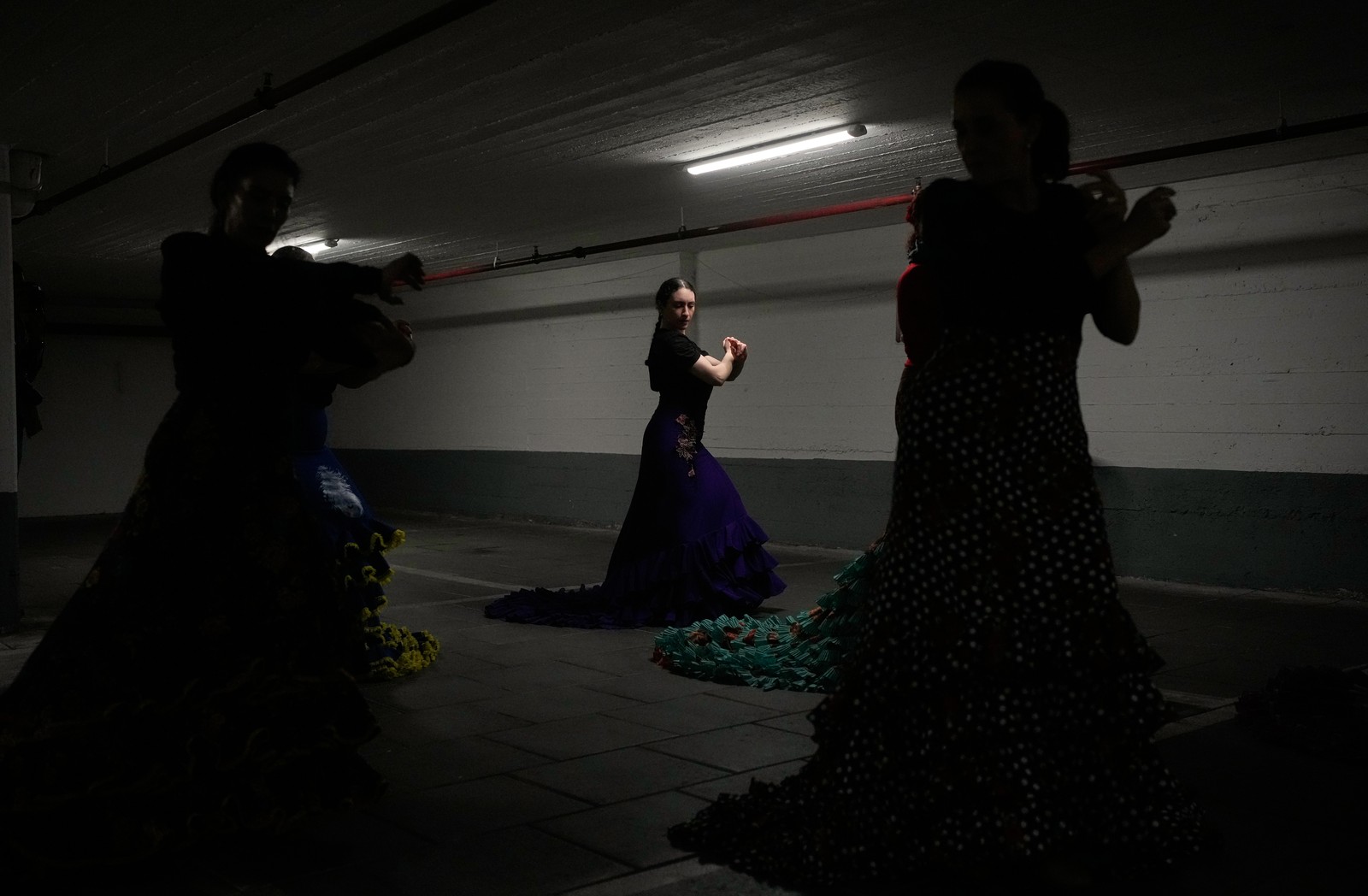 Flamenco studentspractice in a dark underground parking garage.