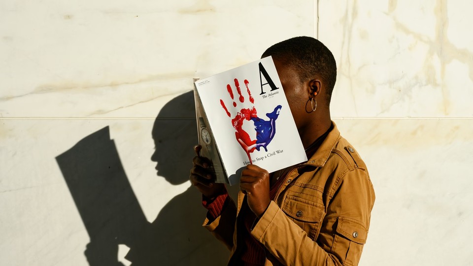 An Atlantic reader holding a copy of the magazine