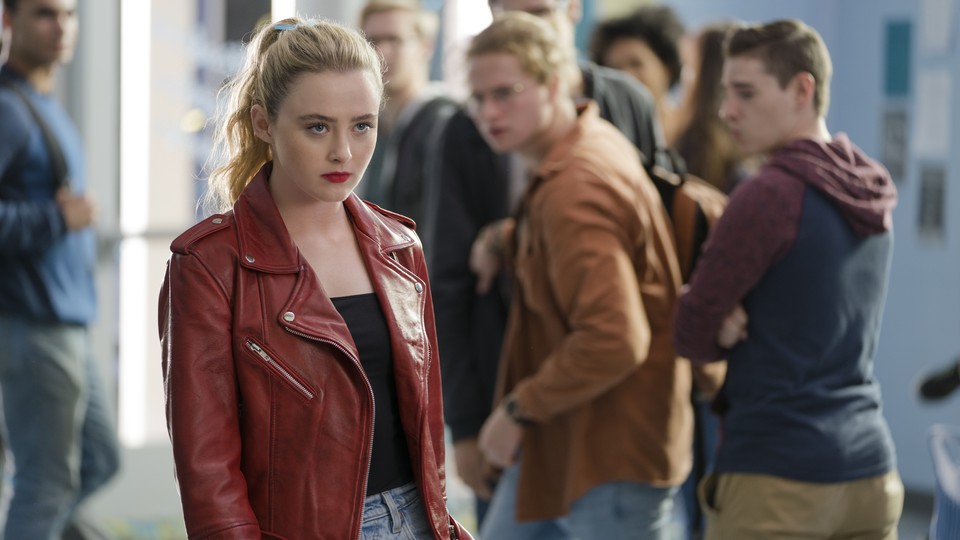 A young woman, played by actor Kathryn Newton, in a red leather jacket