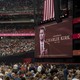 a color photograph of Charlie Kirk's memorial with a large crowd of people
