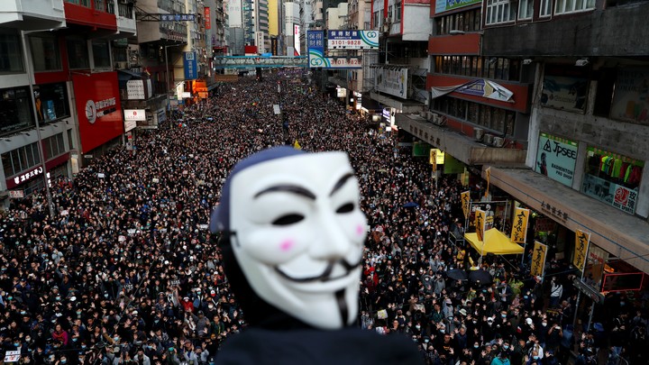 A protester wearing a Guy Fawkes mask heads a demonstration in downtown Hong Kong.