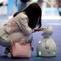 A woman interacts with a small robot.