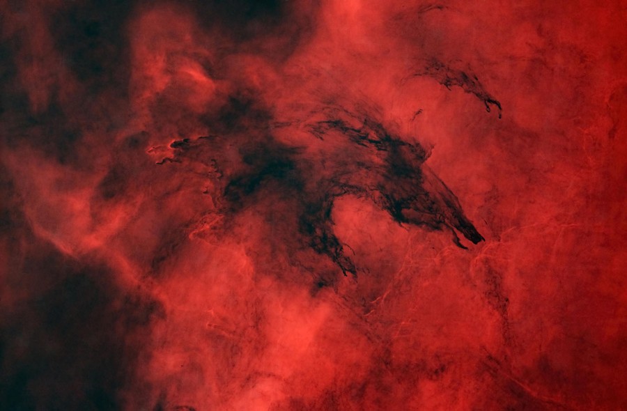 Swirling dark clouds against a glowing red backdrop suggest the shape of a running wolf.