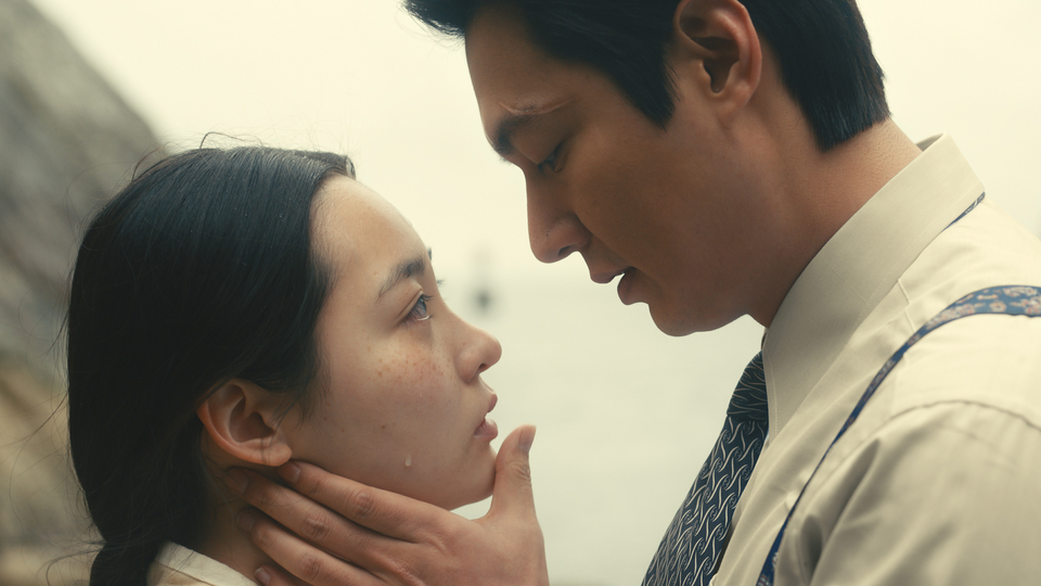Lee Min-Ho holds Minha Kim's face in his hands as a tear rolls down her cheek in a scene from "Pachinko."