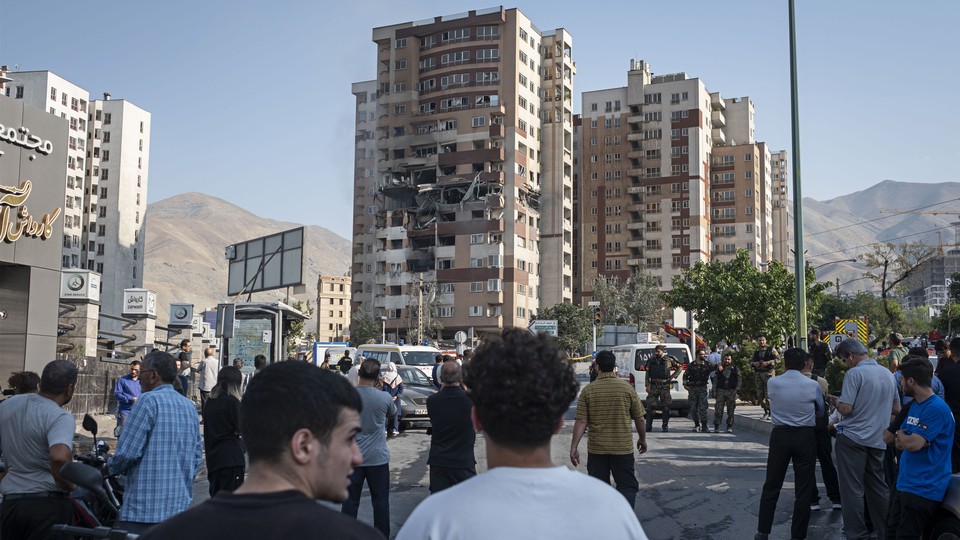 People gather at the scene of a residential complex struck by Israel in Tehran.