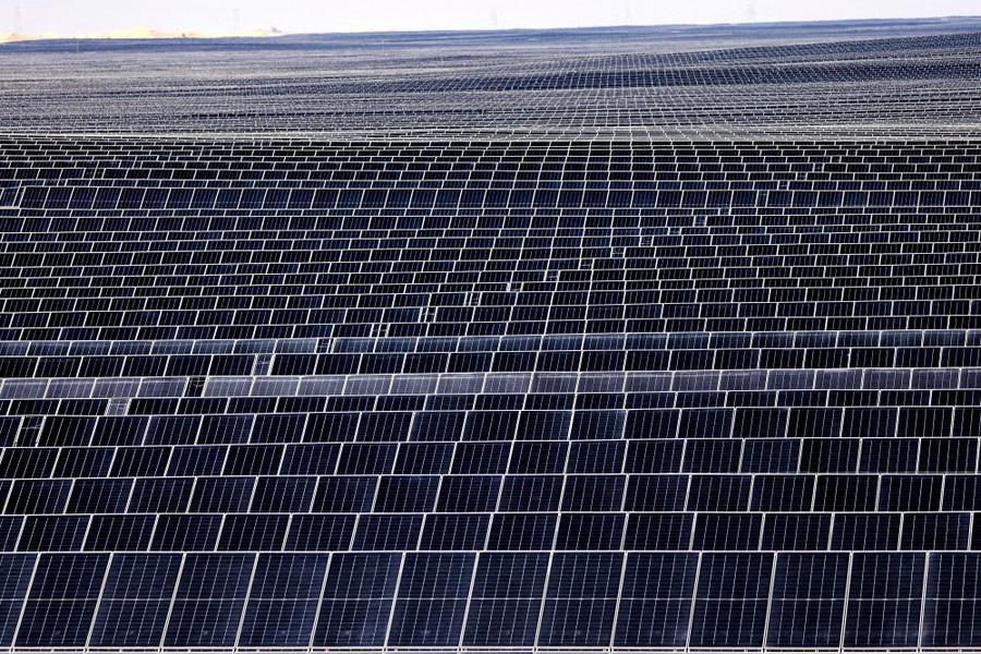 Rows of photovoltaic panels stretch to the horizon.