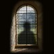 An illustration of a shadow behind a stained-glass window
