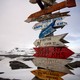 A signpost with the distances to various destinations against a snowy background