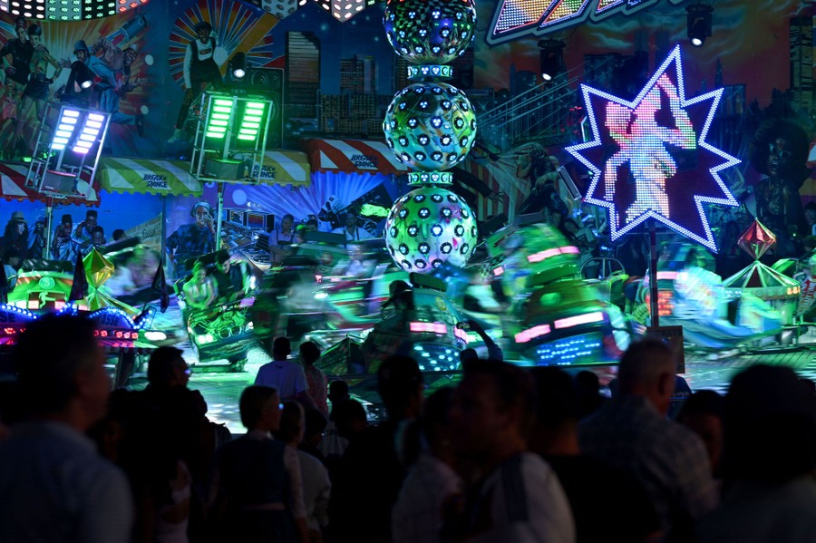 People watch other festivalgoers on a chaotic carnival ride.