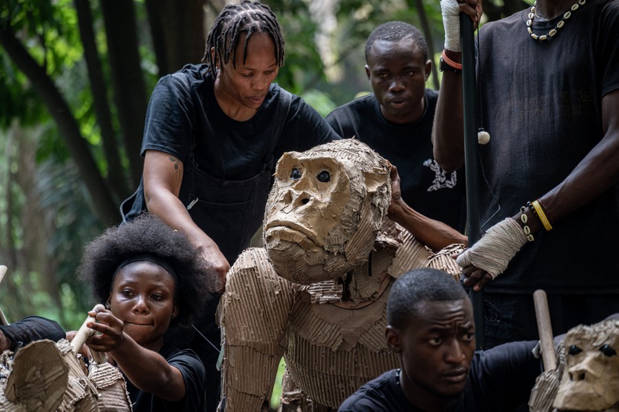 Puppeteers crouch next to a life-sizedgorilla puppet.
