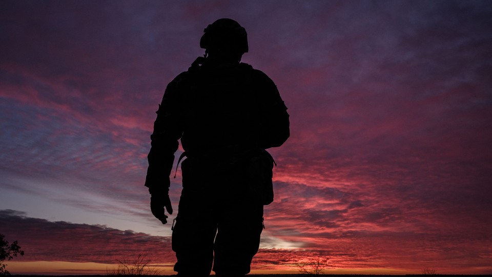 Silhouette of soldier over a sunset sky