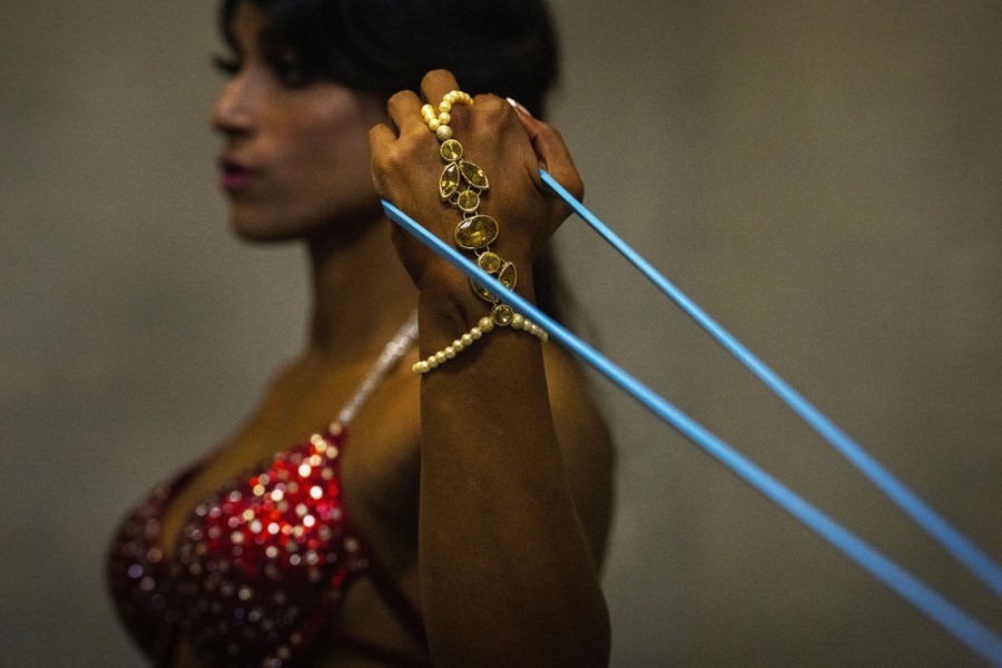 A female bodybuilder pulls on an elastic band.