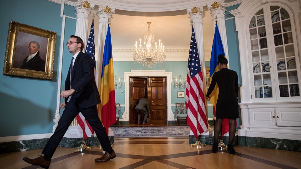 State Department staffers prepare the blue Treaty Room for a visit from the Romanian president.
