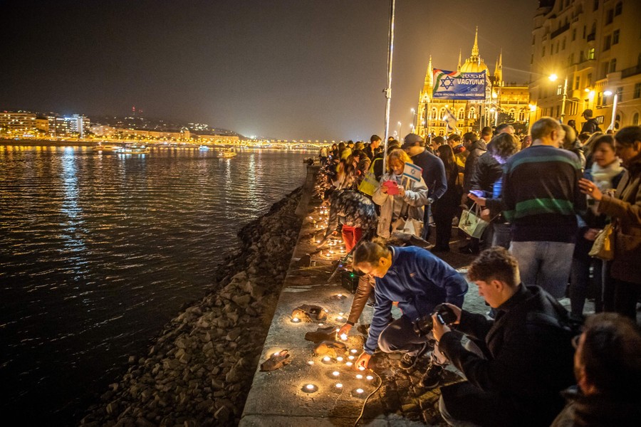 A pro-Israeli crowd places candles beside a river.