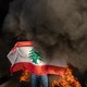 A protester holds up the Lebanese flag on the streets of Beirut.