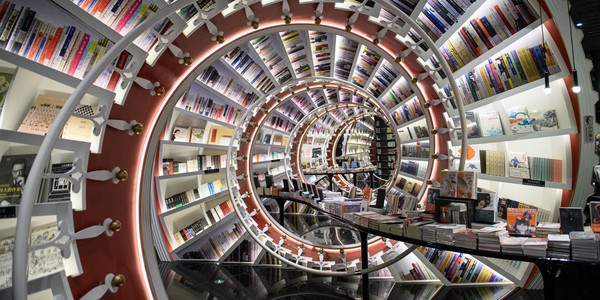 The interior of a bookstore, looking down a tunnel made of spiraling bookshelves