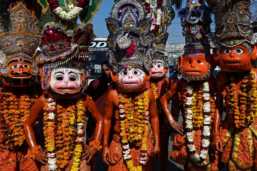 A group of people wear costumes and monkey masks.